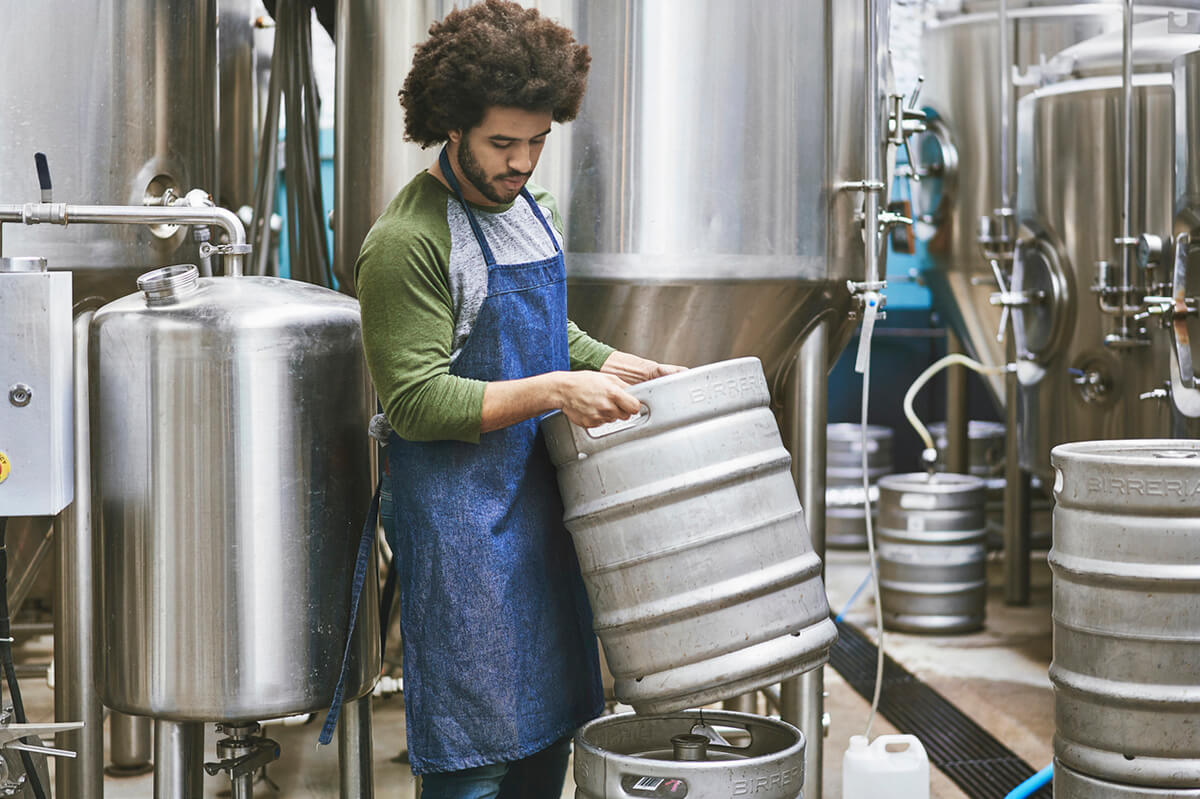 Young man cleans equipment in backroom